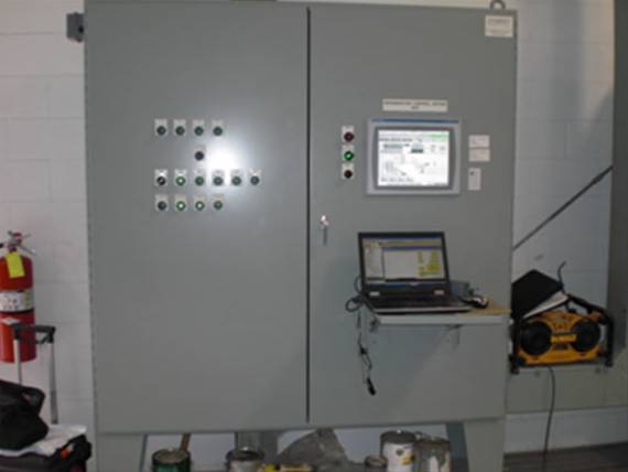 Industrial control panel with HMI screen, laptop connection, push buttons, and automation controls for gas processing systems.