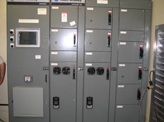 Industrial control cabinet with HMI screen, motor control center panels, and automation hardware for gas processing systems.