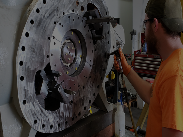 Technician servicing industrial compressor components for integrated gas processing and energy service support.