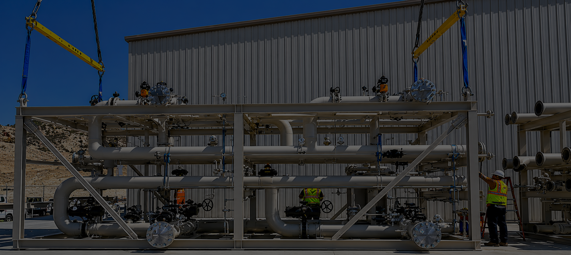 Large skid-mounted gas processing system with industrial piping, valves, and field installation support for compression and process equipment.